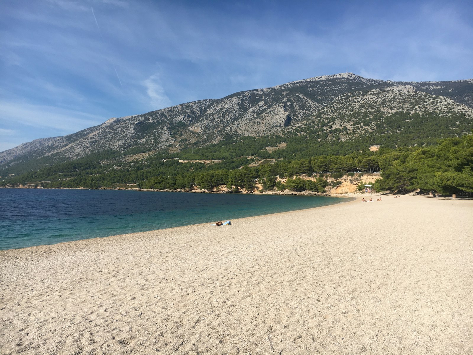 Zlatni Rat beach below the mountains of Brač